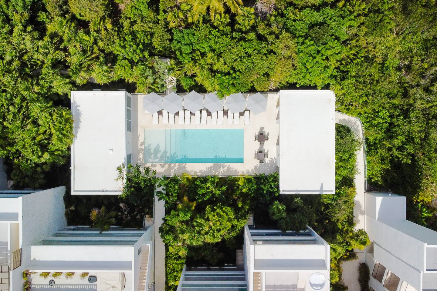 Vista de dron de la exuberante selva y la hermosa piscina ubicada cerca de su condominio, un lugar tranquilo para relajarse y descansar en cualquier momento.