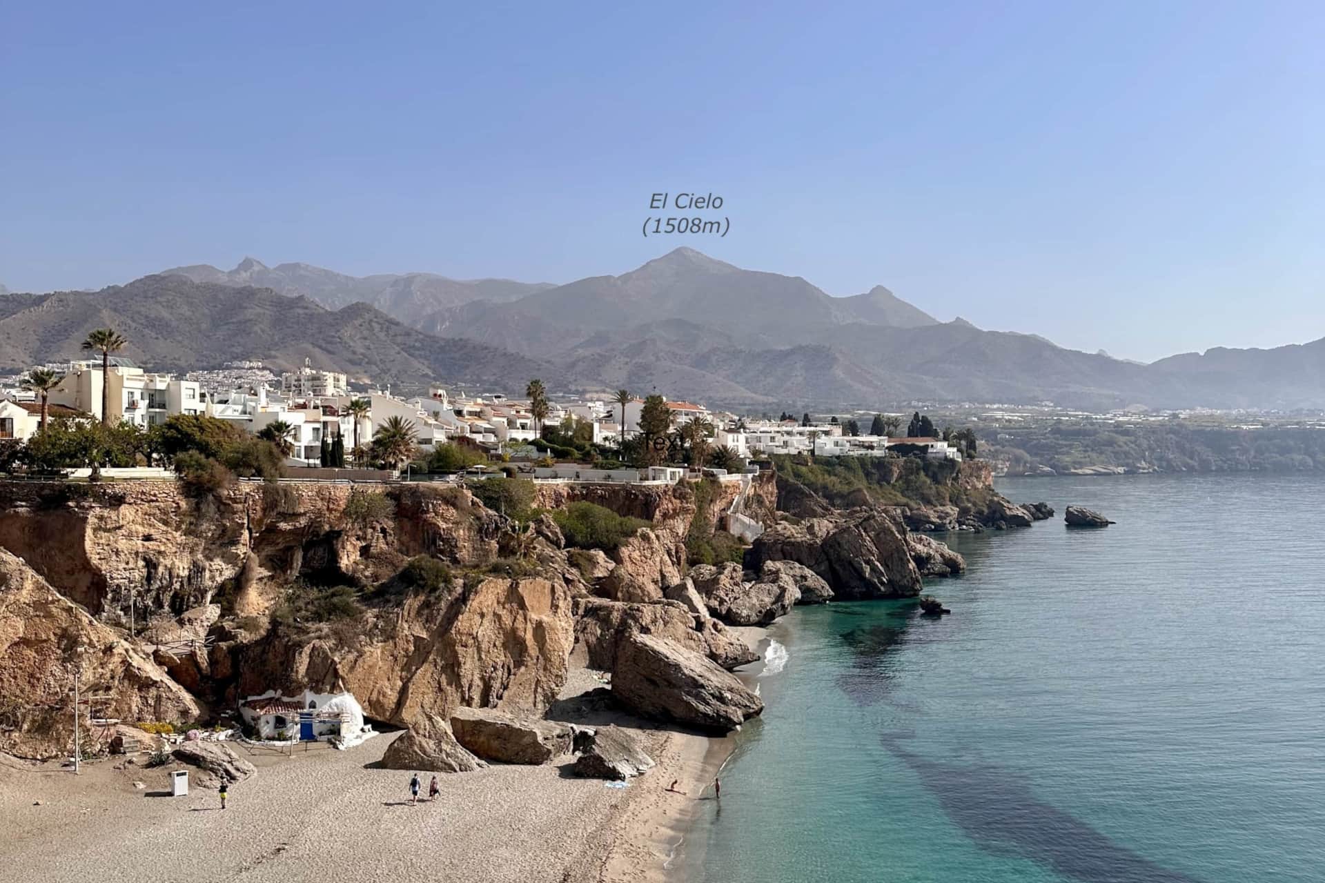 View of El Cielo peak (1508 m) from the Balcón de Europa in Nerja with beach and Mediterranean Sea