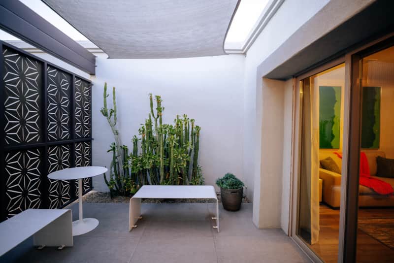 Front courtyard with shade sails, privacy panels and desert plants.