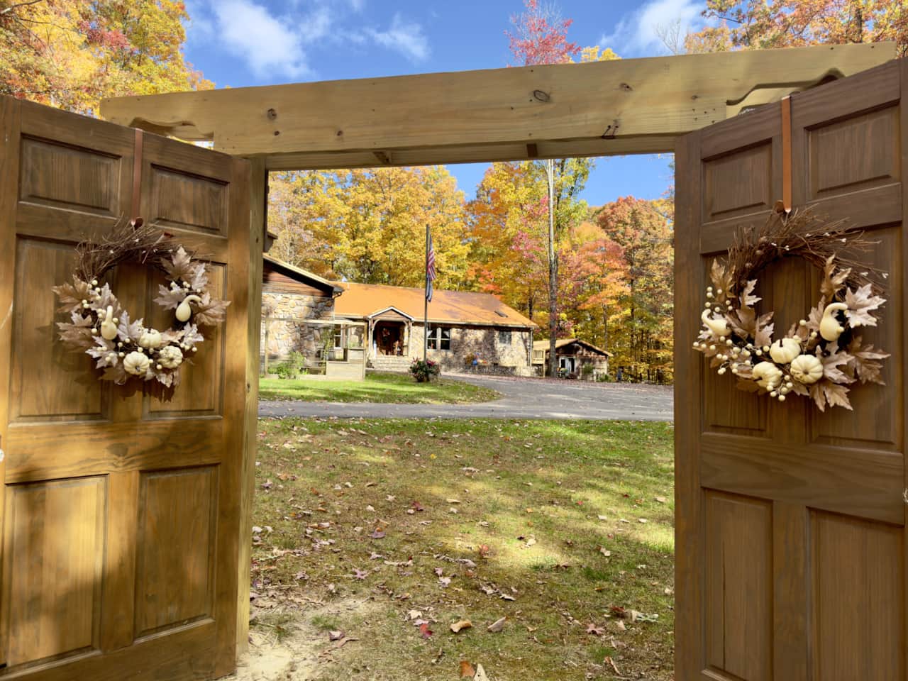 View of Sweet Retreat Lodge framed by the wooden entry doors of the wedding venue in Autumn.