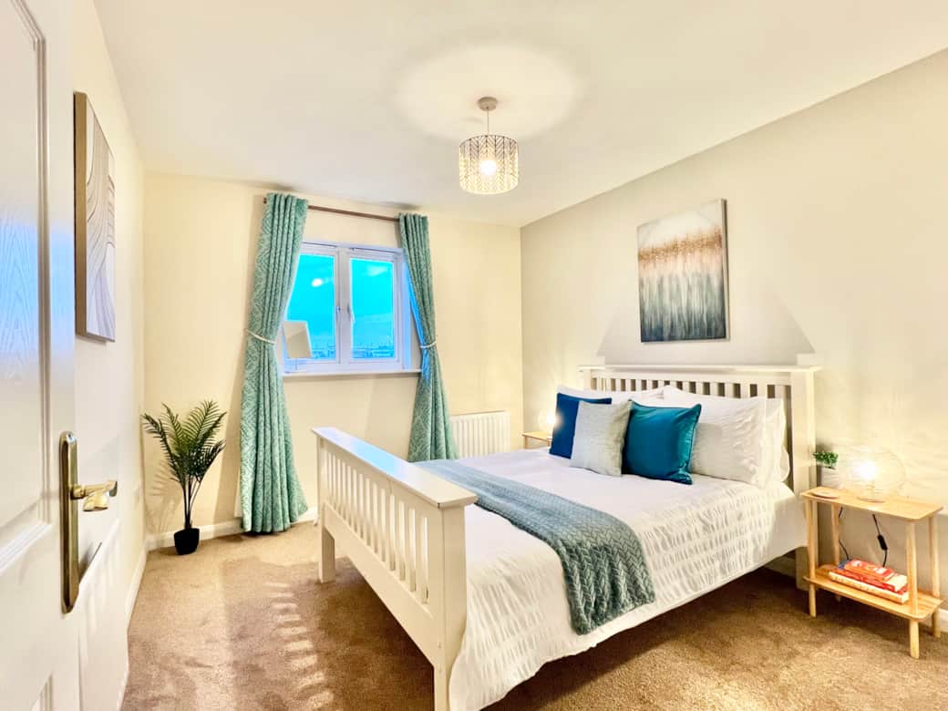 Bedroom 2 - Stylish room with natural light, art work, and a wardrobe to hang clothes 