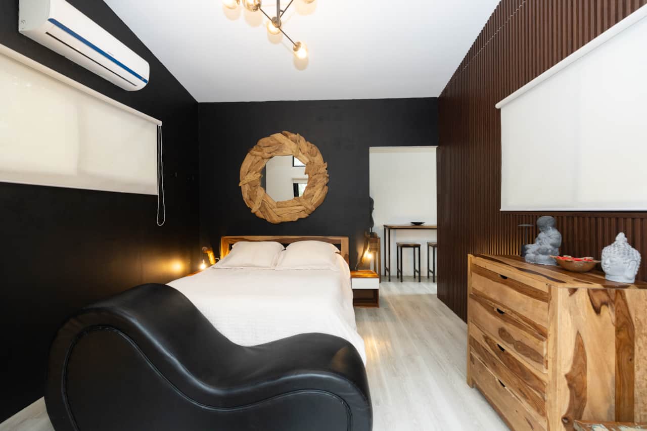 Stunning dark interiors define the cozy bedroom of this Scandinavian cabin in Panama.