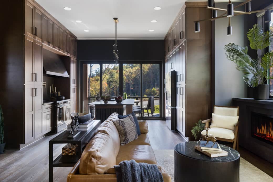 Expansive sliding doors connect the kitchen and living area to a mountain-view balcony