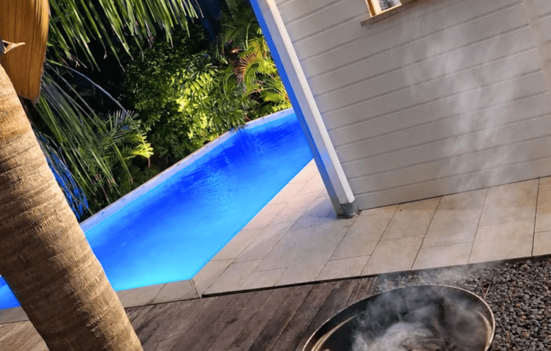 La piscine illuminée le soir, au cœur du jardin tropical