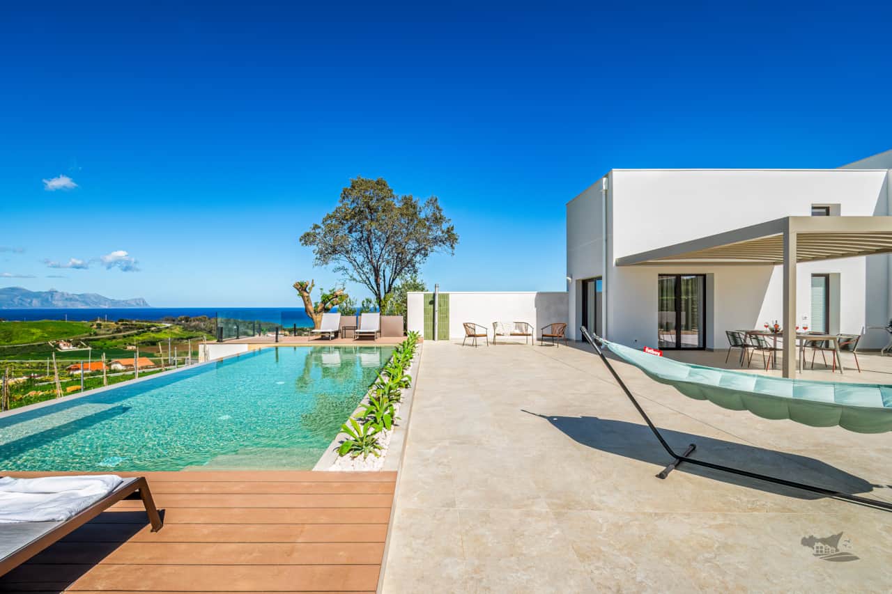 Lounge by the pool with uninterrupted views of Sicily’s breathtaking coastline.