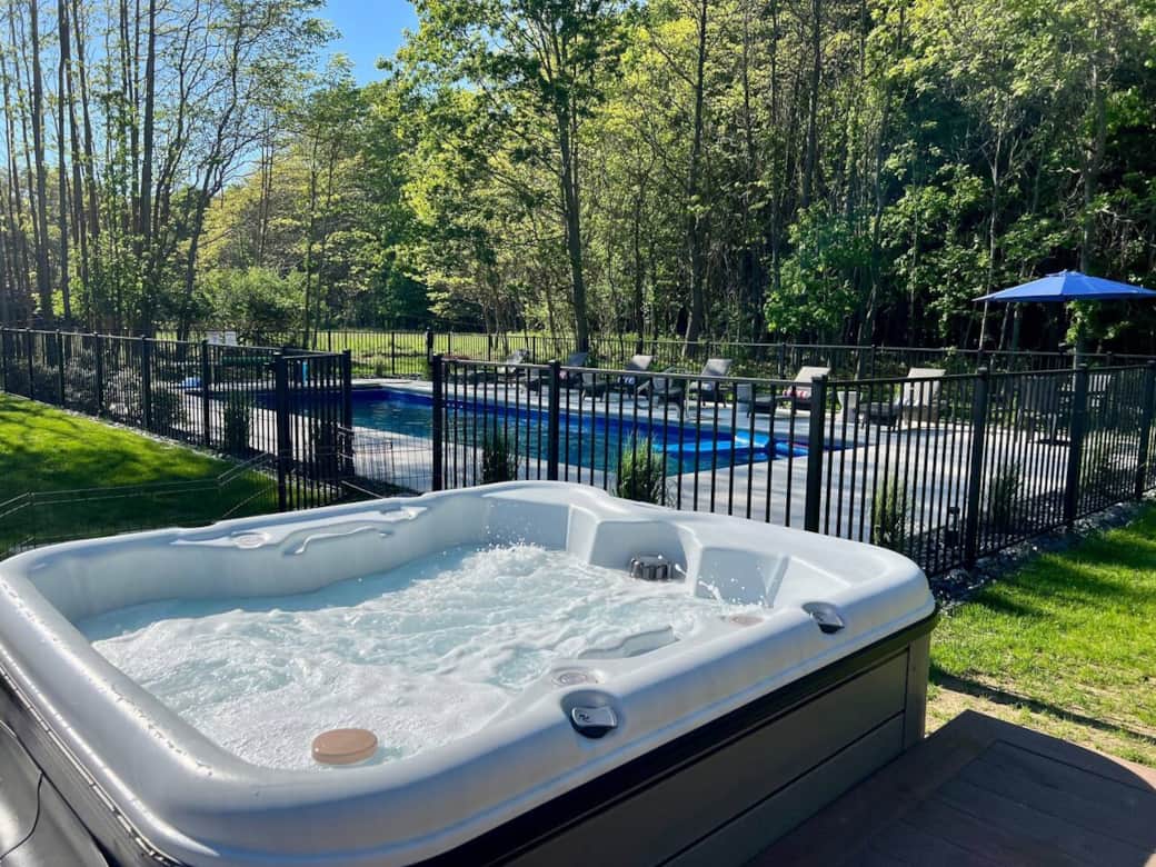 Hot tub leading to swimming pool in the back yard