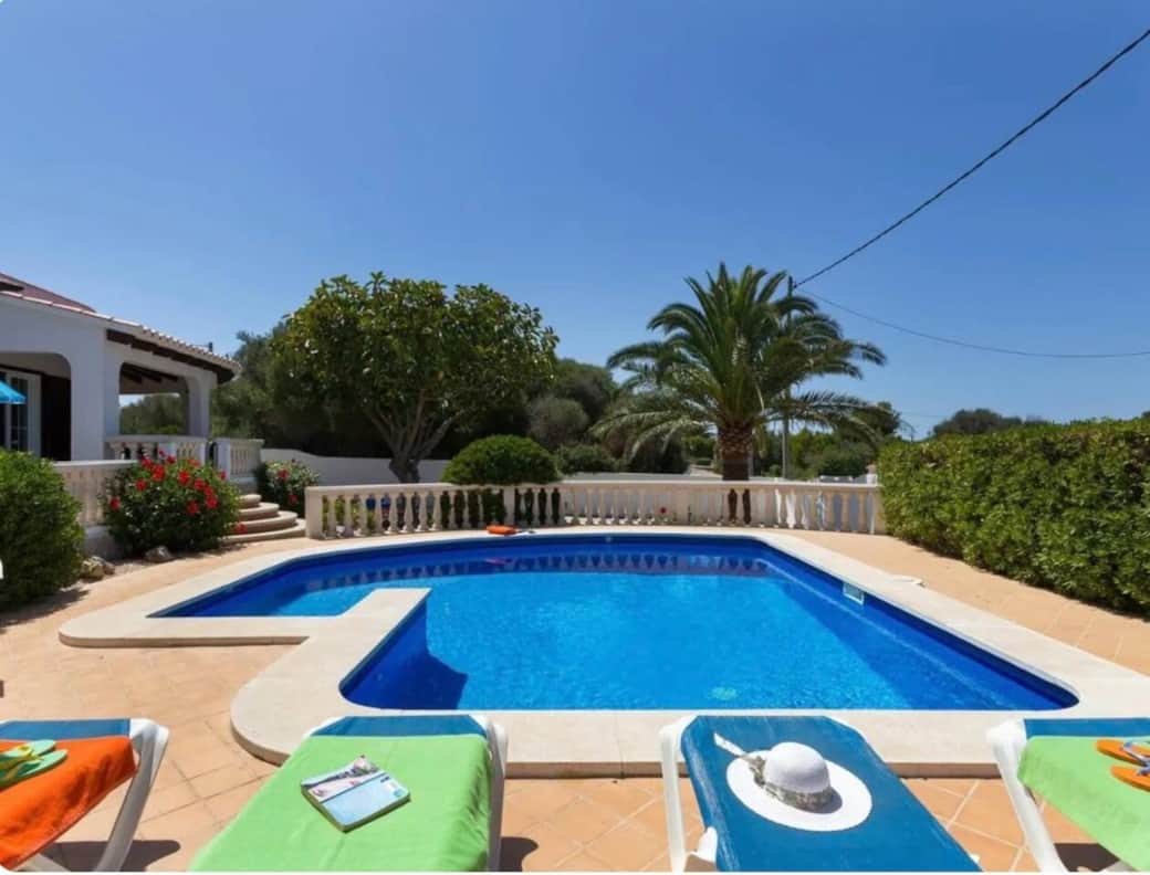 Pool and patio with sun loungers and umbrella