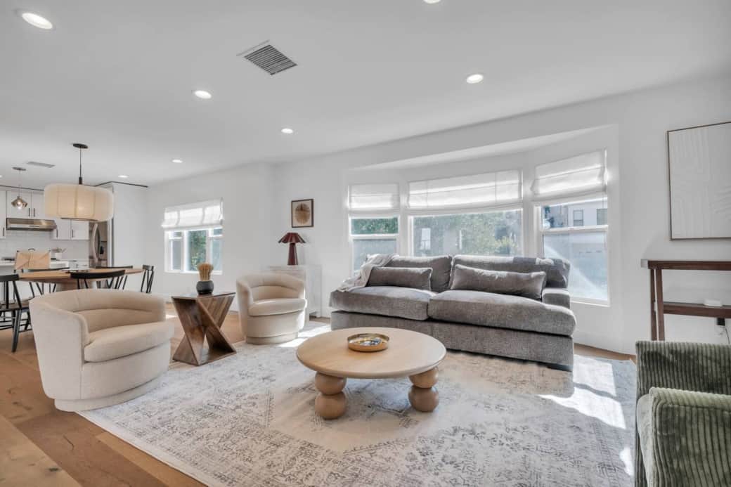 Living room with seating area, large windows, and open access to the dining space Living room with seating area, large windows, and open access to the dining space