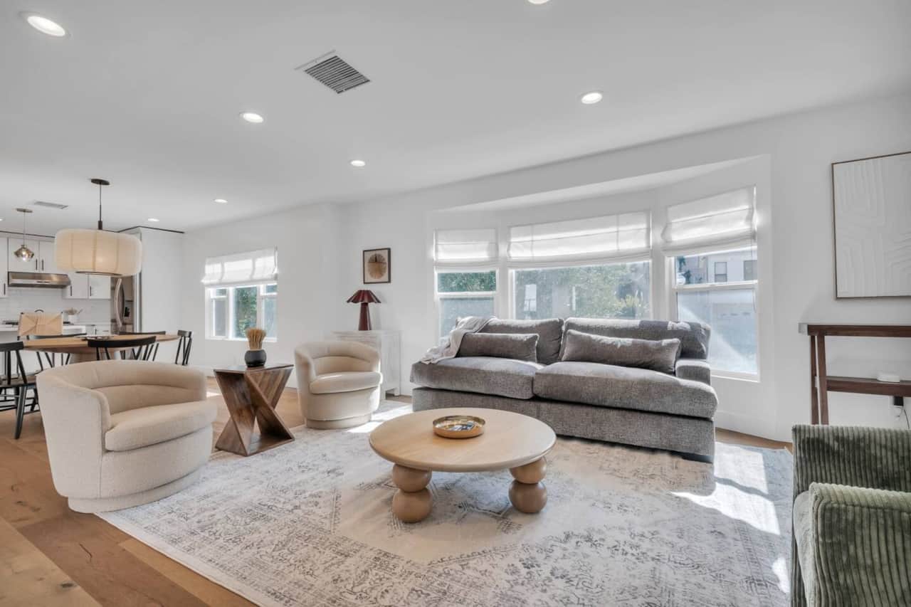 Living room with seating area, large windows, and open access to the dining space