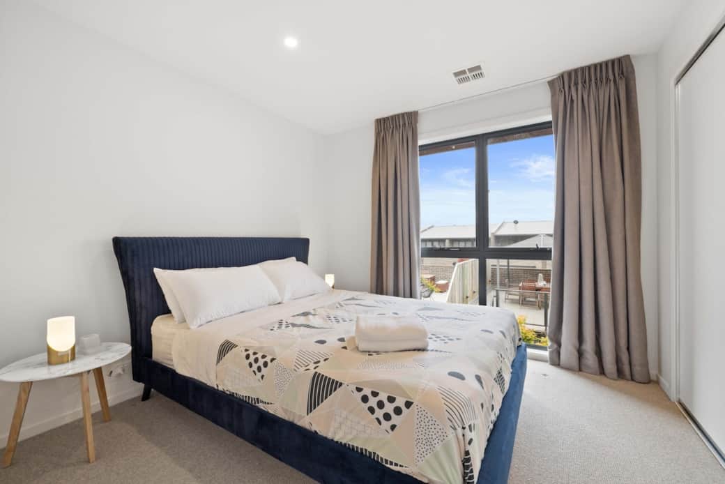 Experience tranquility in the heart of the city. Our cozy bedroom features a plush bed, perfect for a good night's sleep. The large window brings in natural light and offers a glimpse of the urban landscape， provides a calming environment.
