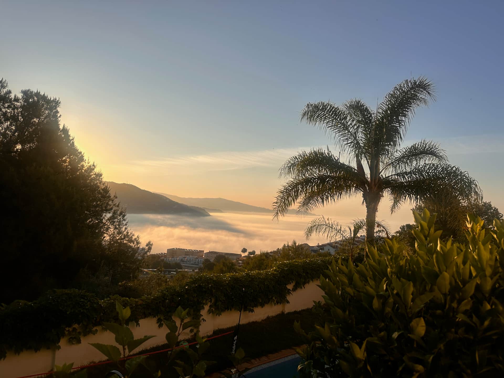Wschód słońca nad Almuñécar z mgłą nad morzem  palmami na Costa Tropical