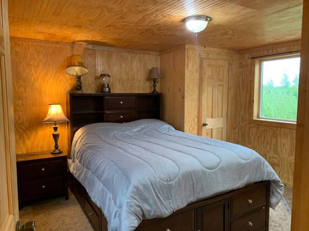 Queen size bed with drawers and storage underneath, as well as small closet to hang clothing.