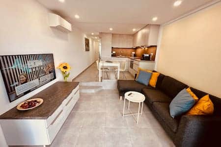 Salón con televisor (Smart-TV) y cocina