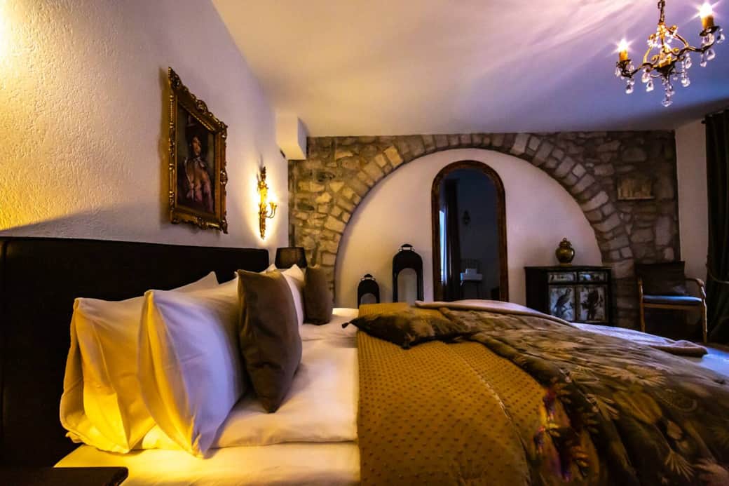 King bed with soft lighting and original stone arch detail