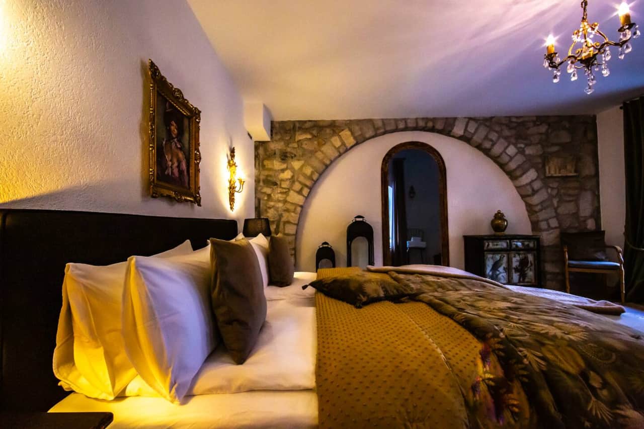 King bed with soft lighting and original stone arch detail