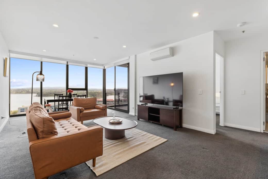 Experience the serenity of the ocean from your living room. This spacious area features comfortable seating and a large window that frames the lake, perfect for relaxation or entertaining guests.