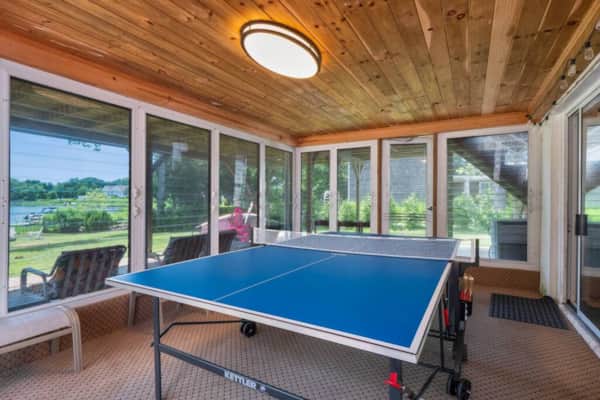 Florida room with a ping-pong table and windows on three sides