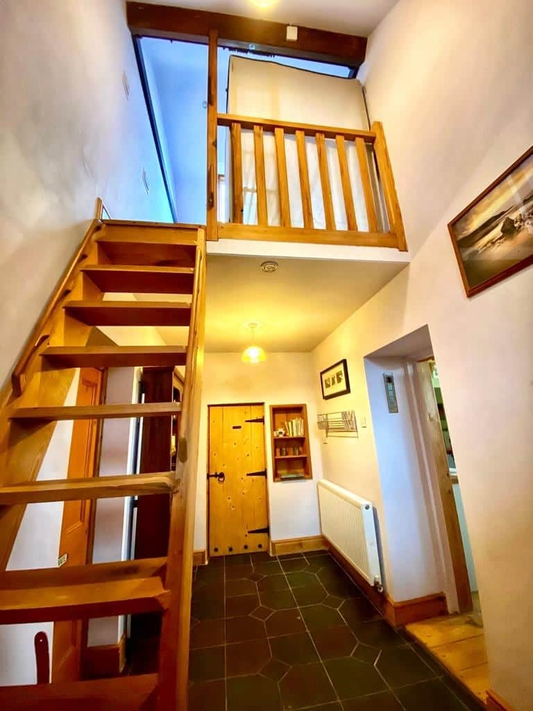 The entrance hall, steep steps up to the loft bedroom, door ahead is to the bathroom, to the right to the main living area