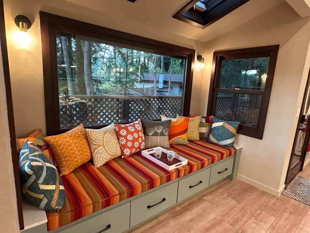 The entry to the kitchen/dining area features a double-sized custom window bench with valley views. A favorite spot in the house to relax and chat with friends in the open plan kitchen and dining area.