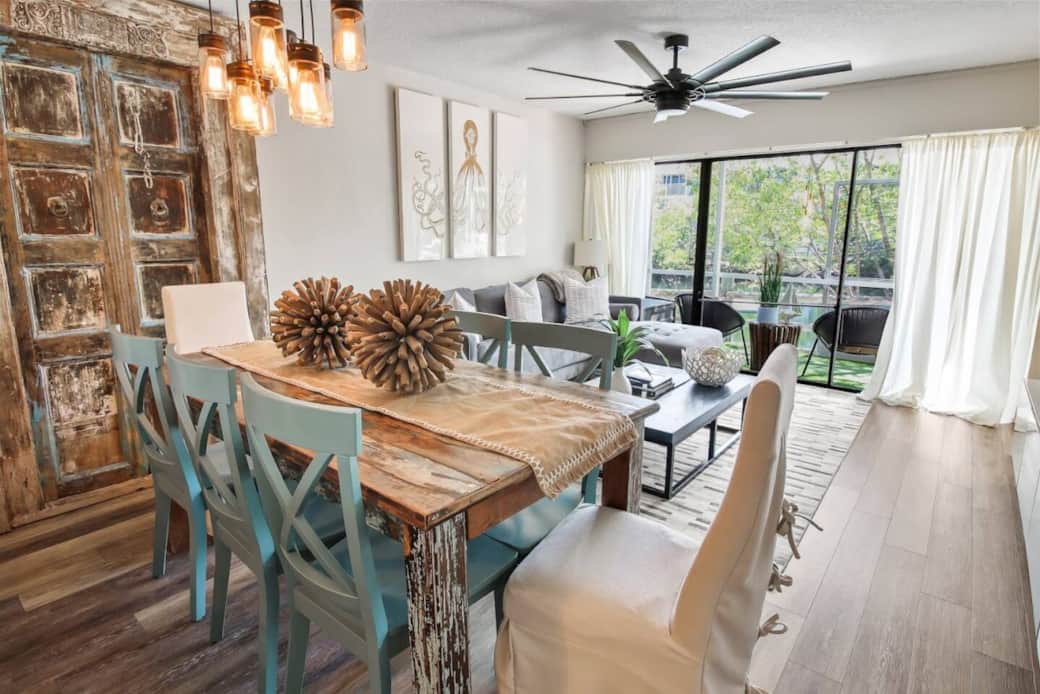 The living and dining space features a stunning antique wood door accent wall that adds character and charm.