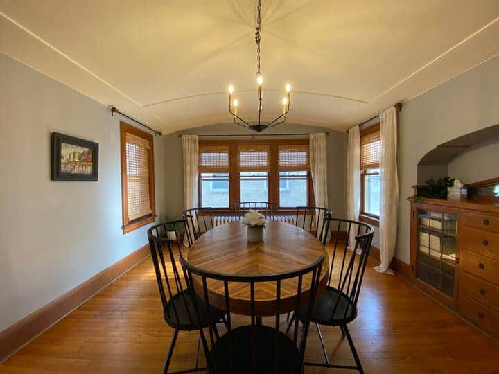 Elegant dining room with a large table and abundant natural light from surrounding windows.