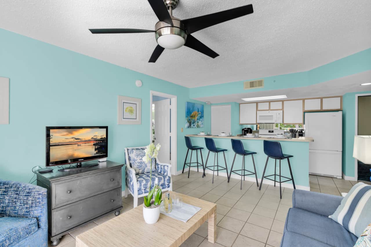 Relax in the open-concept living area with cable TV, cozy seating, and breakfast bar dining for four
