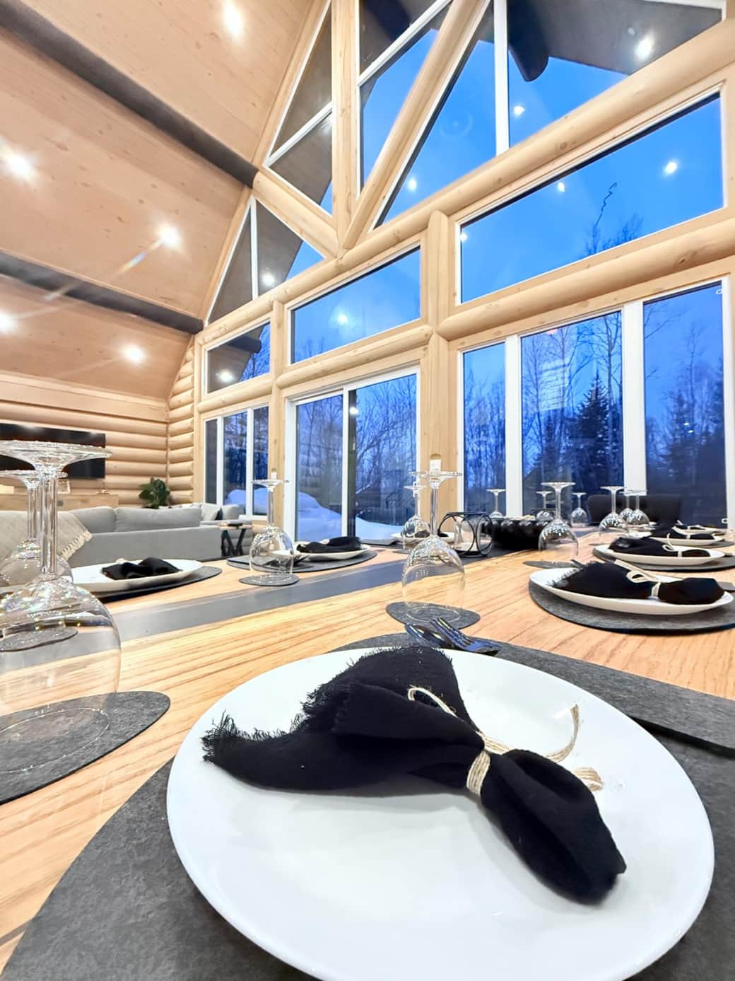 Salle à manger et salon avec grande fenêtration et plafond cathédrale