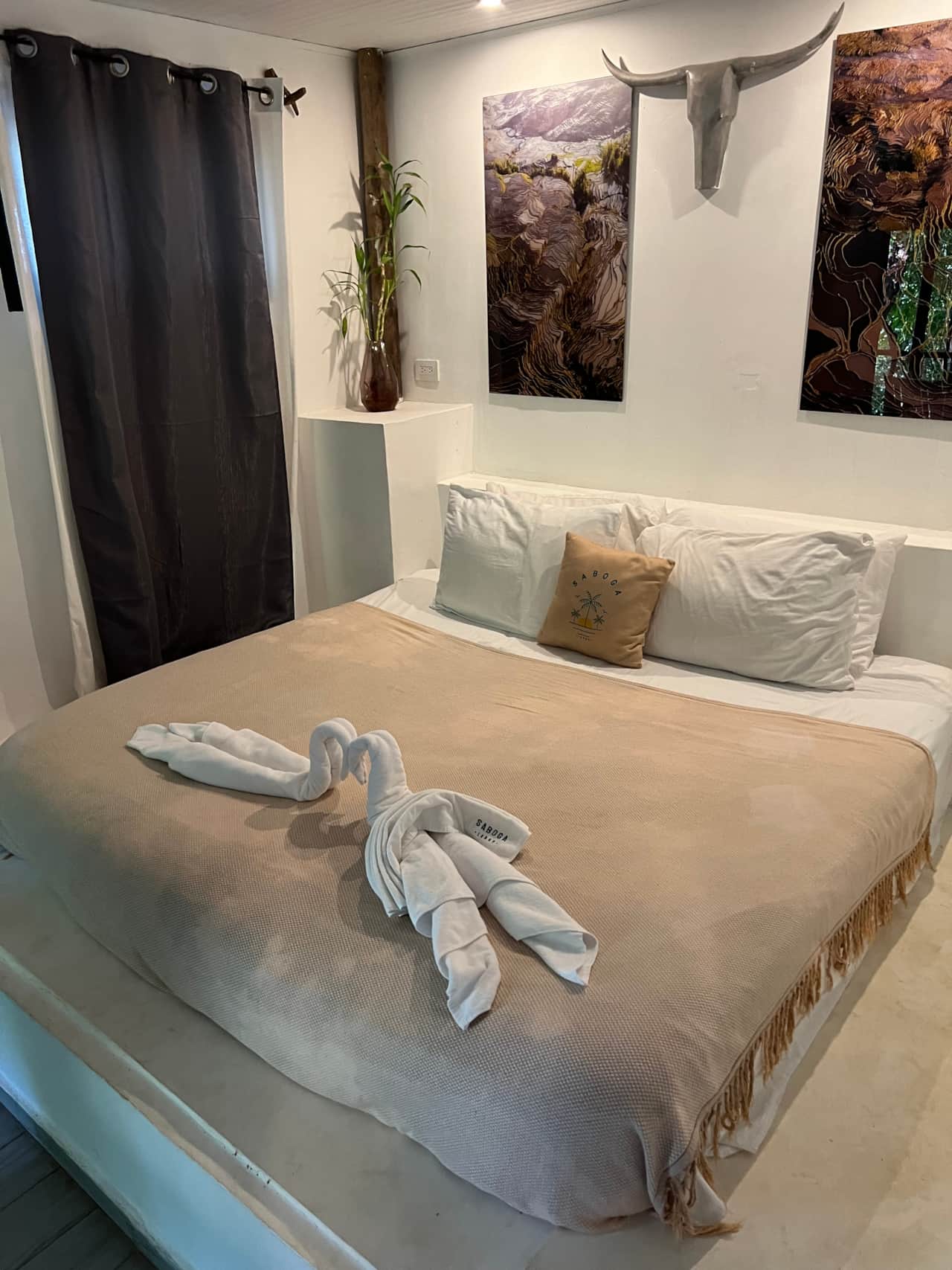 Bedroom at Saboga Lodge with white walls, warm textiles and landscape art, Saboga Island