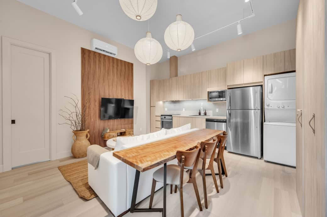 Loft à aire ouverte avec cuisine entièrement équipée, comptoir en bois massif pour les repas. Salon lumineux avec canapé-lit Queen et télé. Idéal pour se détendre, pour le télétravail ou recevoir deux invités supplémentaires.
