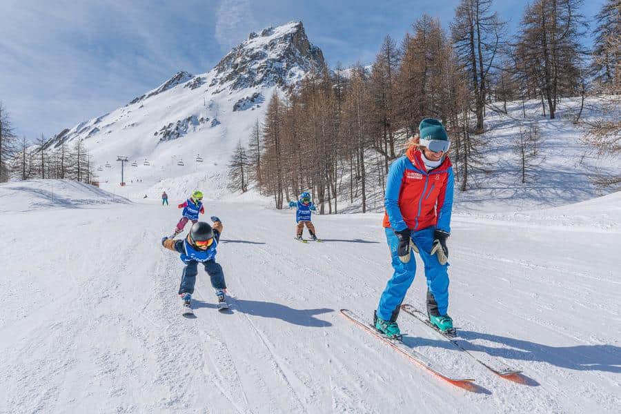 Cours de ski enfants avec moniteur ESF sur les pistes enneigées, Serre Chevalier Vallée