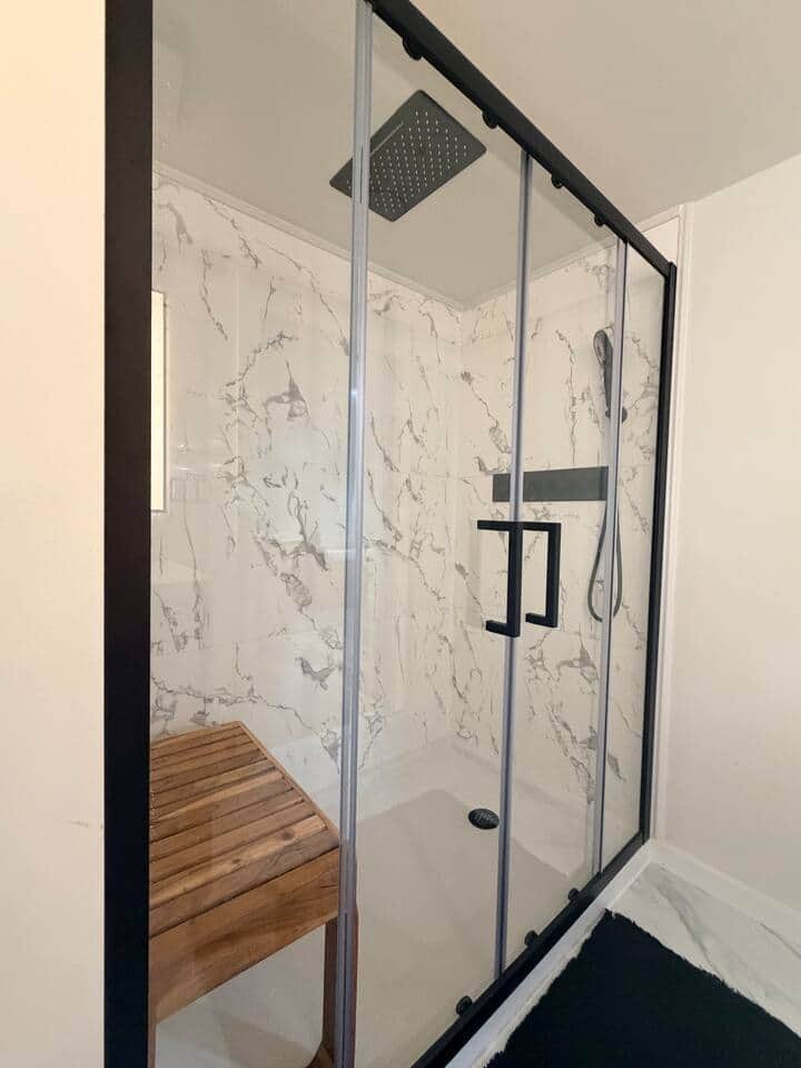 Walk-in shower with waterfall shower head.