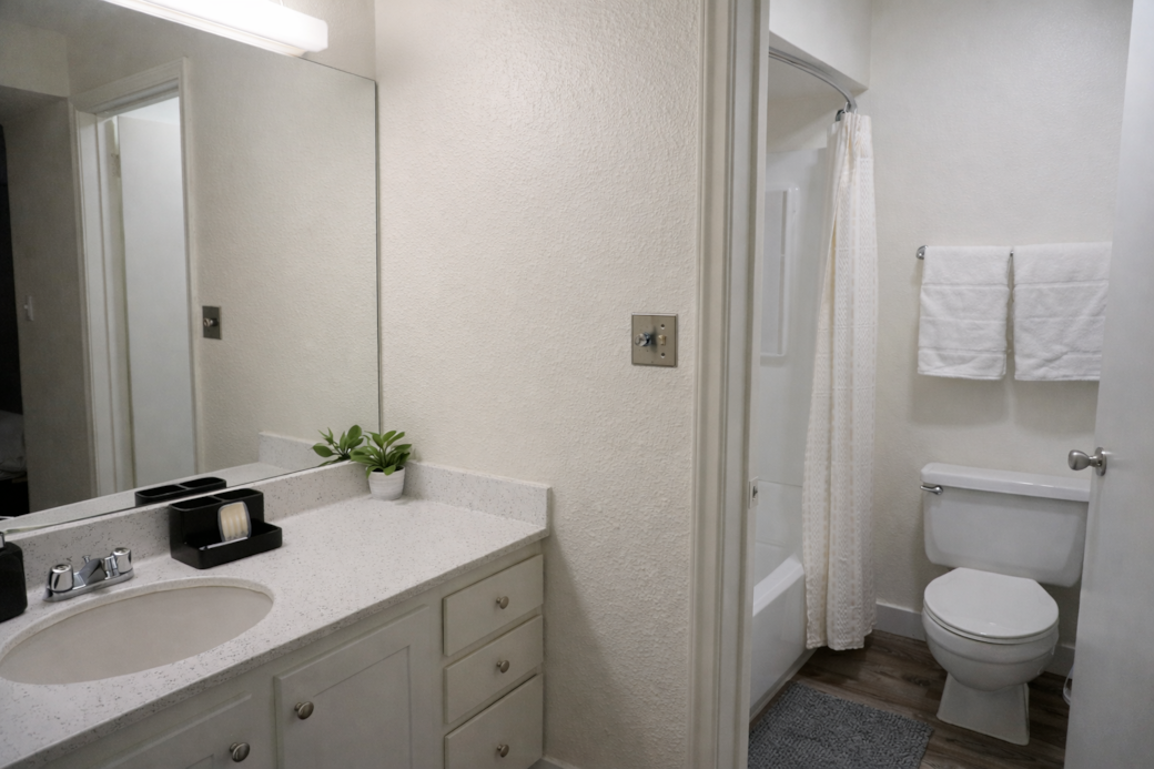 Bright, minimalist bathroom featuring a  tub and all the essentials thoughtfully stocked.