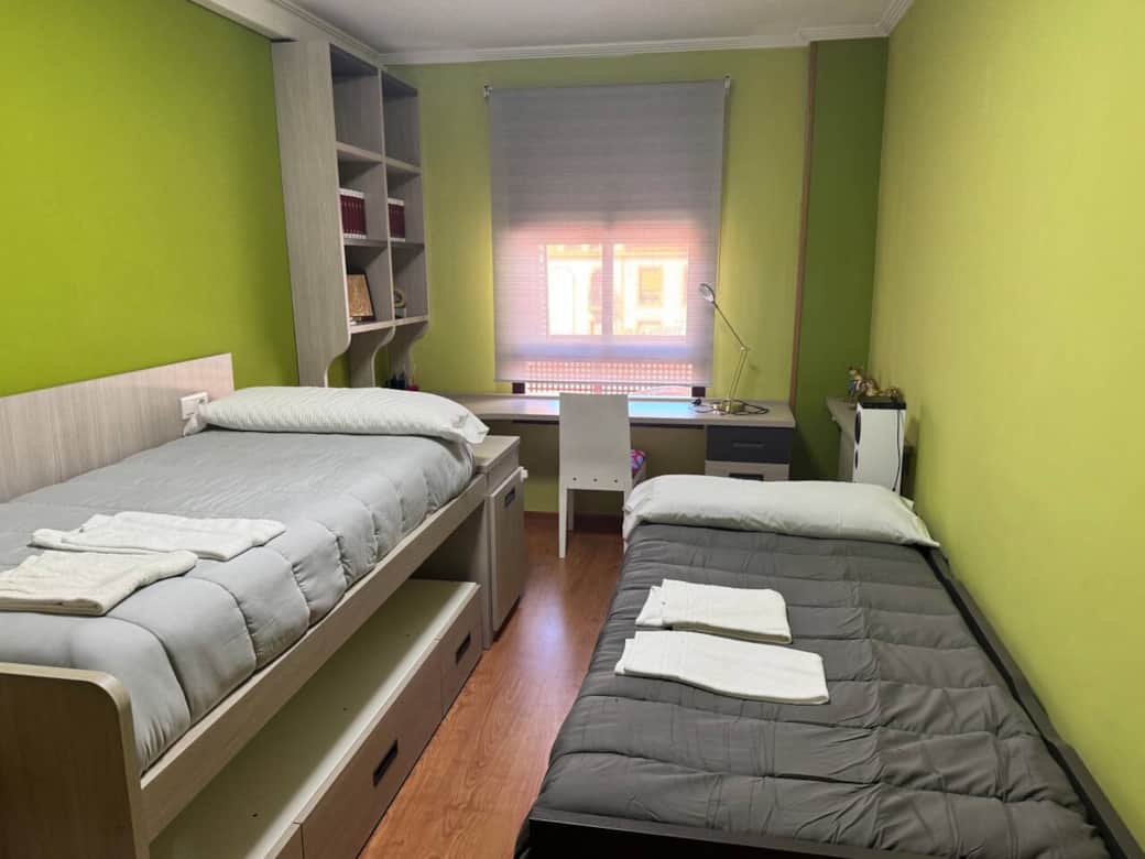 Dormitorio con dos camas individuales y escritorio Dormitorio con dos camas individuales y escritorio
