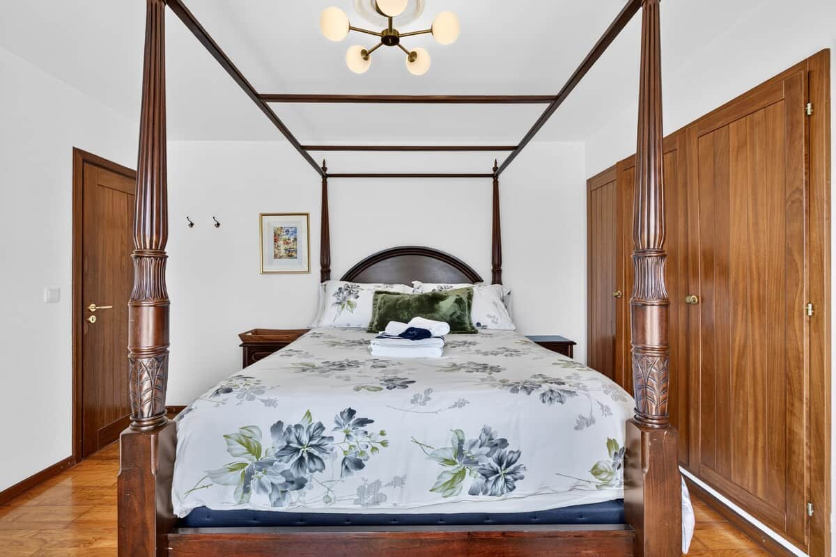 Grand four-poster bed and ample built-in wardrobe storage inside the elegant Lisboa Room.