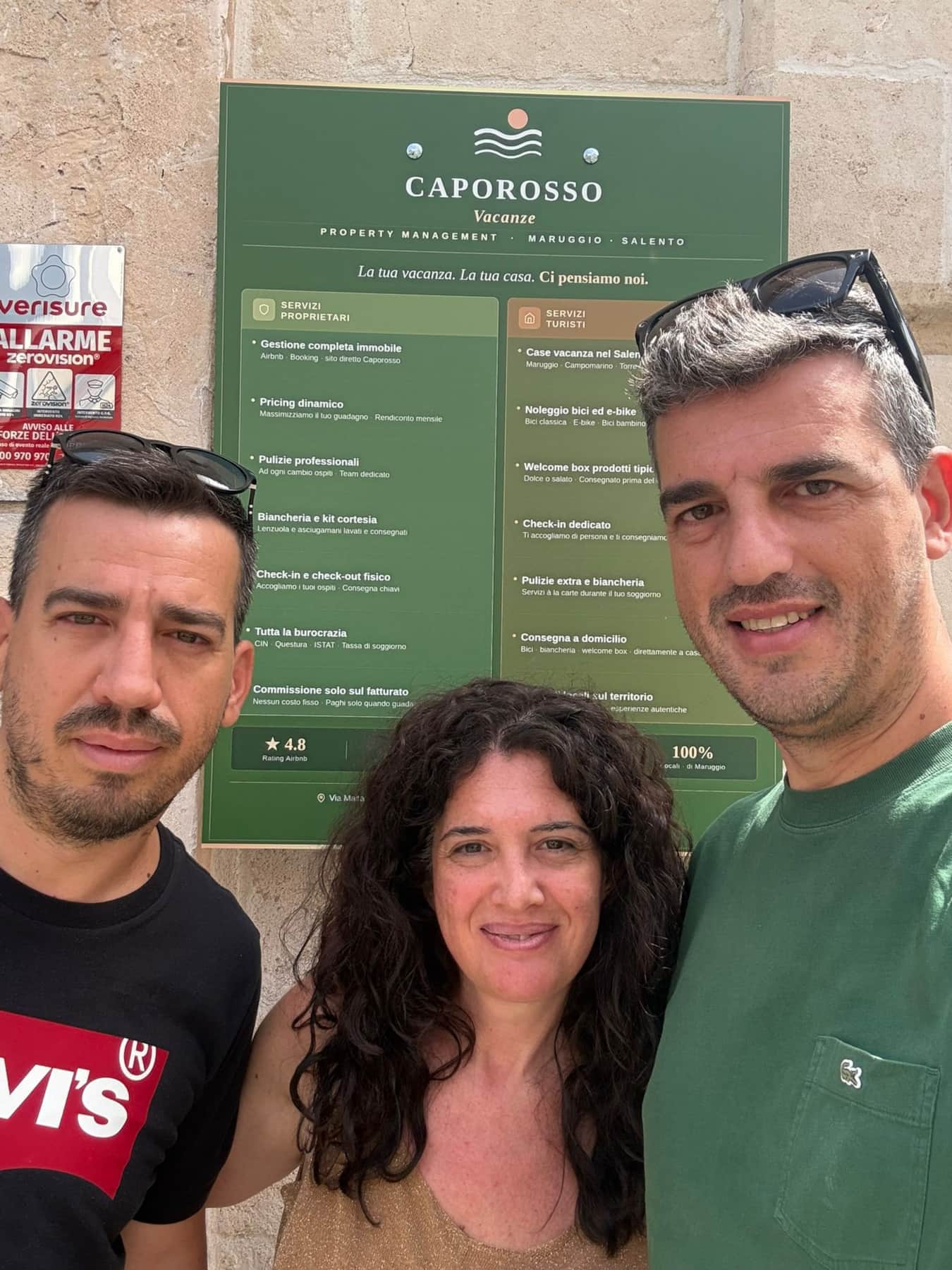 Il team Caporosso Vacanze — Angelo, Lucia e Antonio davanti all'insegna di Via Malta 47, Maruggio