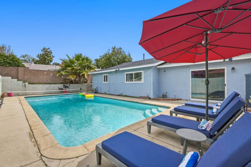 Poolside loungers and umbrellas offer a relaxing space for sunbathing or unwinding outdoors.