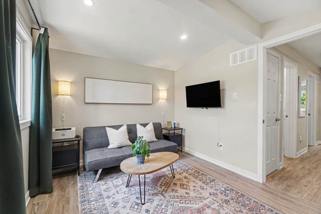 Cozy upper-level family room or office space featuring a futon, accent coffee table, and flat-screen Cozy upper-level family room or office space featuring a futon, accent coffee table, and flat-screen