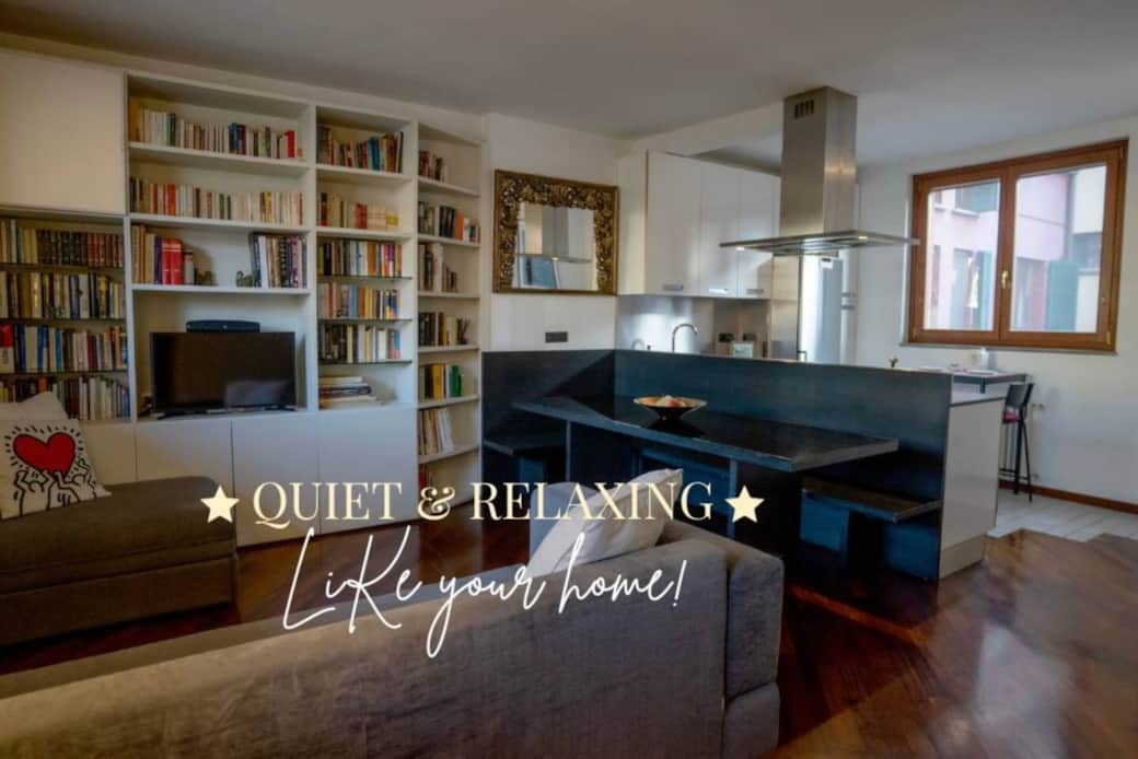 Spaziosa sala con grande tavolo da pranzo e cucina di design a vista con angolo colazione. Nella sala sono presenti due divano letto singoli e una ricca libreria per il relax. Spaziosa sala con grande tavolo da pranzo e cucina di design a vista con angolo colazione. Nella sala sono presenti due divano letto singoli e una ricca libreria per il relax.