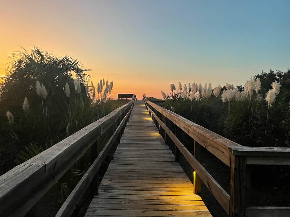 Long walkway heading towards the beach at sunset