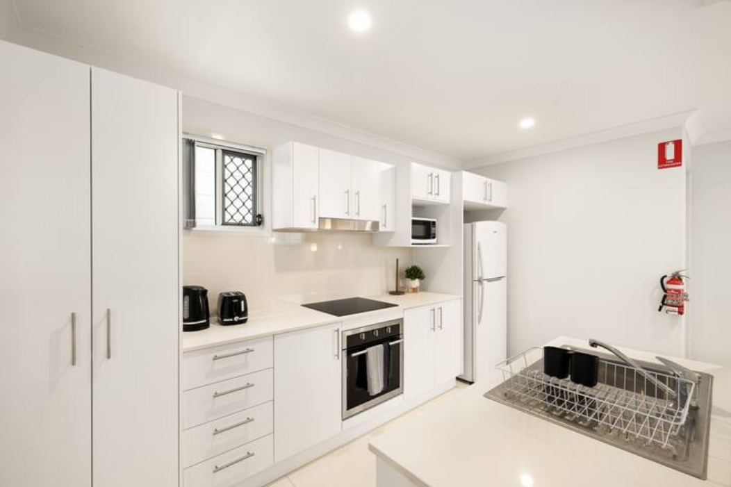 Kitchen: Sleek kitchen with ample storage, modern appliances 
