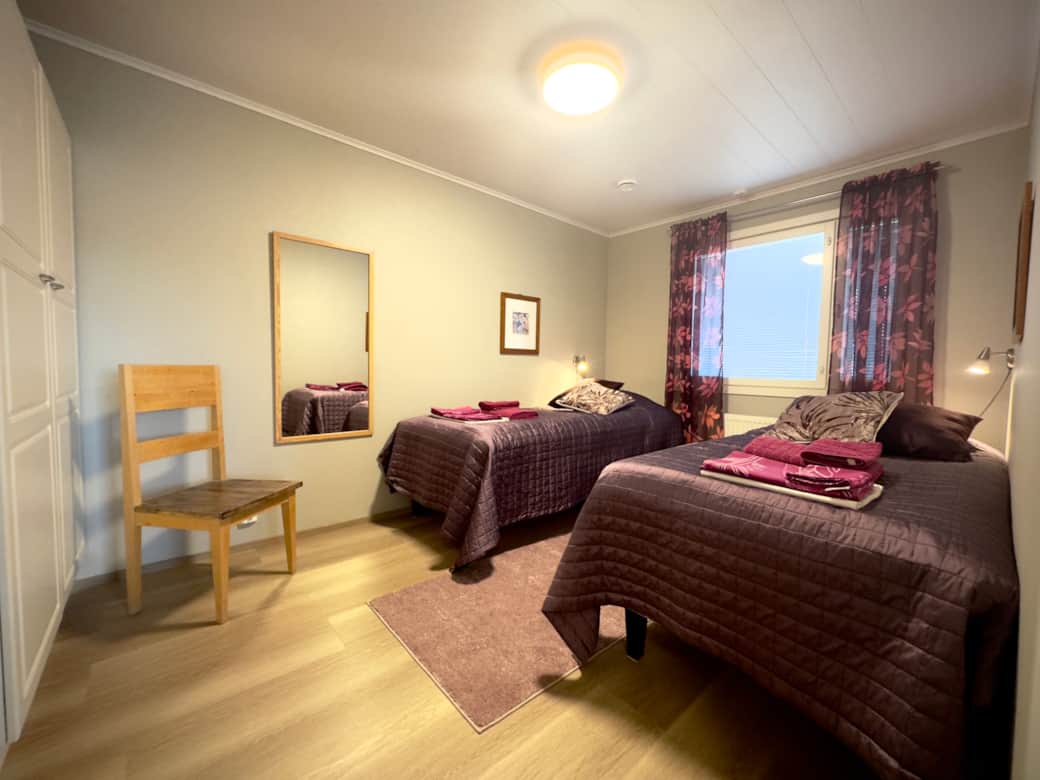 The bedroom has two separate beds a and a wardrobe.