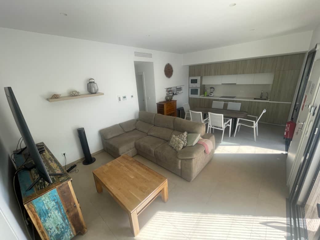 Bright, welcoming living room with a cozy couch and access to the terrace