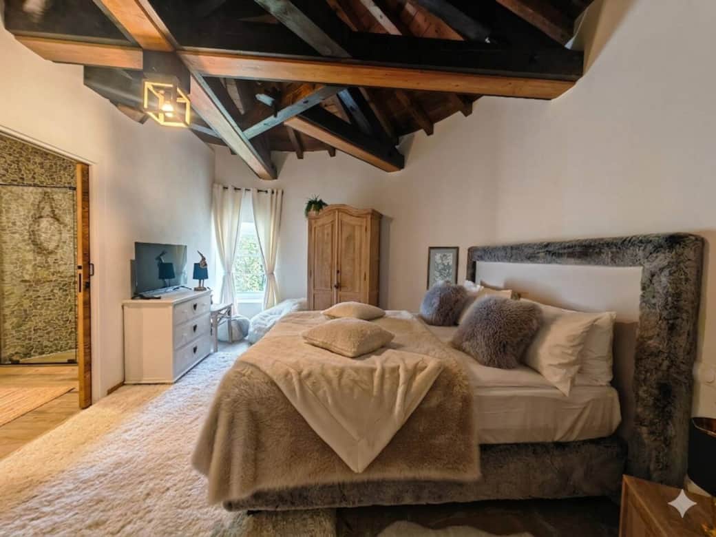 Bedroom with exposed beams and a king bed, designed for a calm and restful stay Bedroom with exposed beams and a king bed, designed for a calm and restful stay