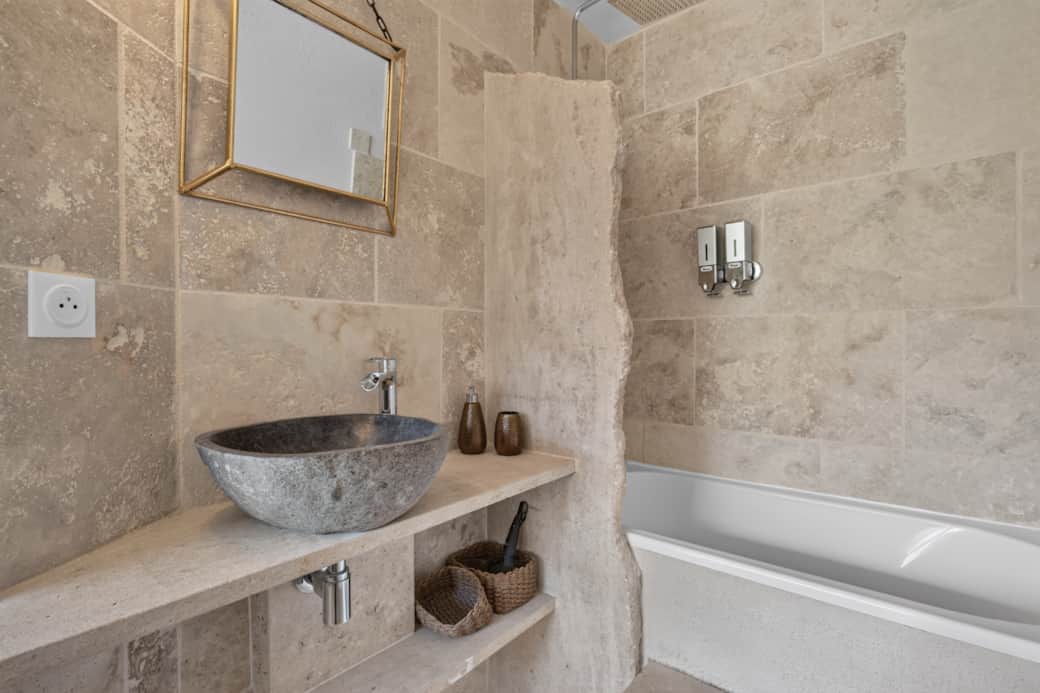 Travertine bathroom, stone bathtub and sink for a truly relaxing moment.