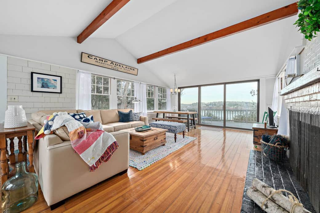 The vaulted living room/dining room has windows on all sides and breathtaking views of the lake