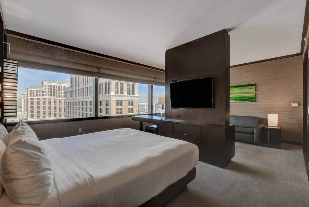 King Bed Facing Strip Views and Modern Wood Accents King Bed Facing Strip Views and Modern Wood Accents