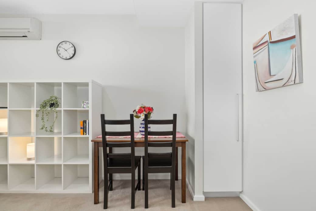 Enjoy meals or work in this cozy dining space, ideal for two. Surrounded by open shelving and soft lighting, the area blends practicality with comfort, making it a perfect spot to unwind or share a quiet moment over coffee or dinner.