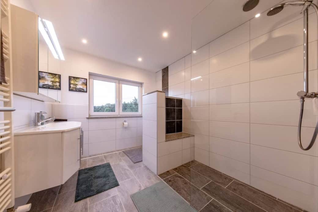 Hochwertiges, neuwertiges Badezimmer mit großzügiger ebenerdiger Dusche und modernen Armaturen