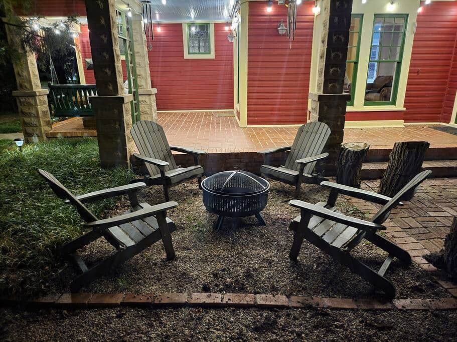 Comfortable seating with a fire pit on the side yard beneath the shade trees.