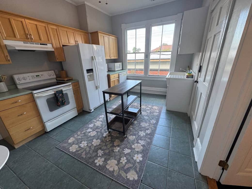 Fully equipped kitchen featuring a refrigerator, dishwasher, glass-top 4-burner stove with oven, microwave, toaster oven, blender, and drip coffee makers. The kitchen is fully stocked with everything you need to cook and enjoy meals during your stay.